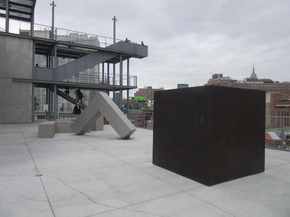 View of the sixth-floor Whitney terrace with Die by Tony Smith, 1962, steel, Whitney Museum of American Art, New York; Purchased with funds from the Louis and Bessie Adler Foundation, Inc., James Block, The Sondra and Charles Gilman, Jr. Foundation, Inc., Penny and Mike Winton, and the Painting and Sculpture Committee); and Robert Morris, untitled (4 Ls), 1965, (refabricated 1970), stainless steel, Whitney Museum of American Art, New York; Gift of Howard and Jean Lipman). Photo by Ken Carpenter. 